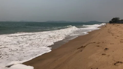 Waves roll onto a sandy beach Stock Footage 127875678