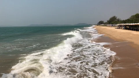 Waves roll onto a sandy beach Stockbeeldmateriaal 127875820