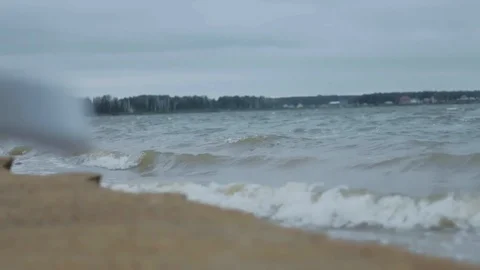 Waves roll on the sandy beach Little town oh background Stormy day Bad weather Video stock 96118764