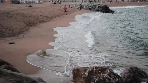 Waves roll on the sandy shore in Barcelona Stock Footage 132682560
