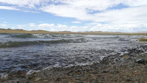 The waves rolled slowly on a pebbly beach. Stock Footage 79130791