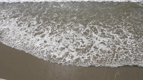 Waves rolling in and out across the hard wet sand￼ Stock Footage 121318425