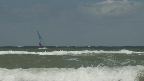 Waves rolling and windsurfer surfing Stock Footage 155926484