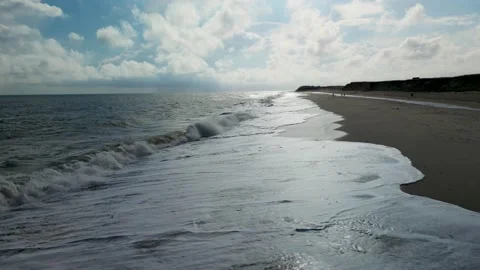 Waves rolling onto the beach in Norfolk Stock Footage 220042752