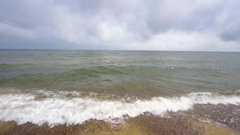 Waves rolling onto beach with storm clouds looming in background Stock Footage 159094732