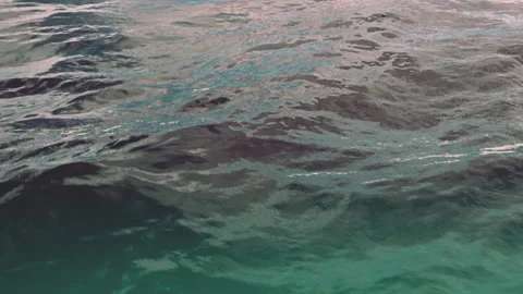 Waves rolling on a beach under cloudy skies in the late afternoon Stock Footage 344388022