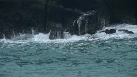 Waves rolling crashing against the rocks on the beach Stock-Footage 319824443