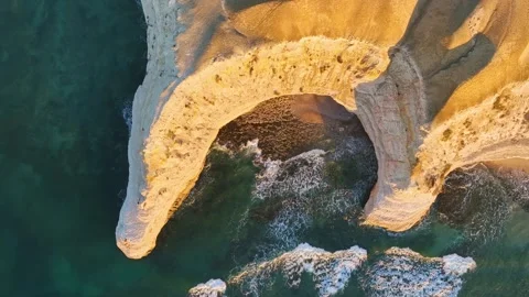 Waves rolling into eroded crescent shaped cove Stock Footage 321790436