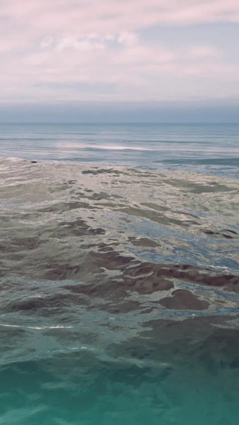 Waves rolling gently beneath a pastel sky at the tranquil seaside Stock Footage 341395944