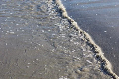 Waves rolling in at low tide on a beach in Wildwood Crest NJ sideways view Stock Photos