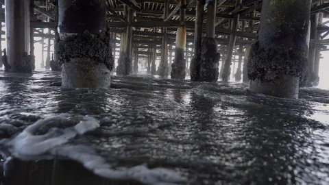 Waves Rolling In Low Under Old Weathered Pier   Stock Footage 96043640