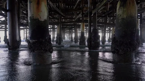 Waves Rolling Out Under Old Weathered Pier   Stock Footage 96043566
