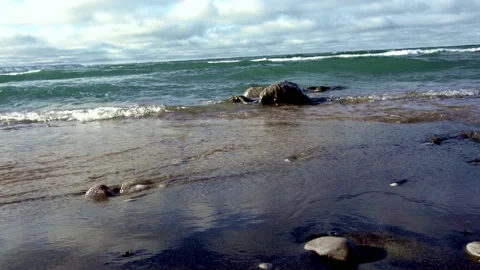 Waves rolling over rocks on a beach at beach level Stock Footage 144903121