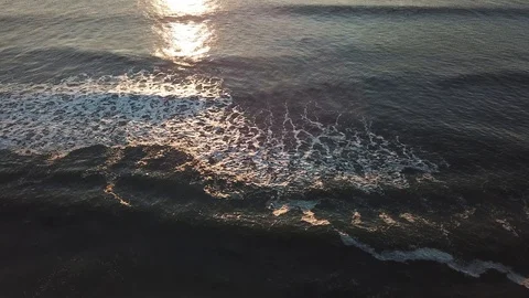 Waves rolling in over the sun's reflection Stock Footage 95162476