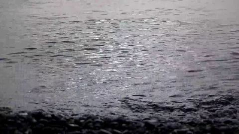 Waves Rolling in on a Pebble Coast Line With Glistening and Shimmering Sea Stock Footage 69242852