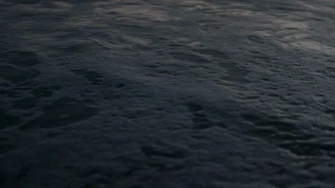 Waves rolling in with reflections of color at dawn Stock Footage 169256479