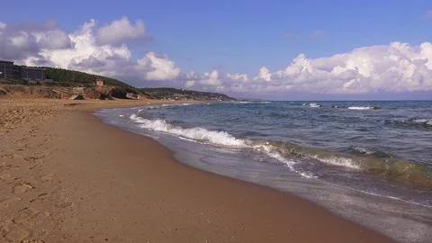 Waves rolling on a sandy beach on a sunny day Video stock 100379552