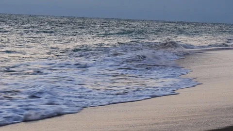 Waves rolling up a sandy beach at sunrise Stock Footage 108642637