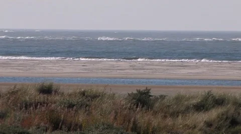 Waves rolling in at shore in nature reserve on Dutch wadden island 動画素材 7735382