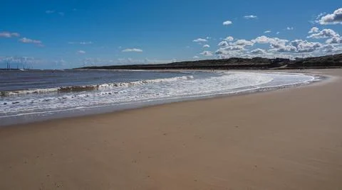 Waves rolling up the smooth sandy beach of the bay, Sea Palling, Norfolk, UK Stock Photos