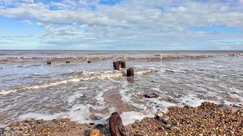 Waves rolling in to the stony beach in slow motion Video stock 265010438
