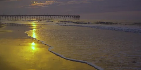 Waves rolling towards the beach and pier at a distance Stock Footage 103493837
