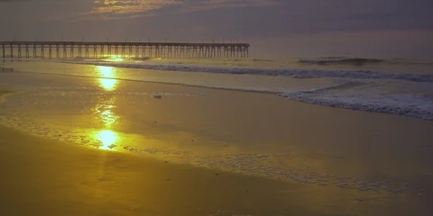 Waves rolling towards the beach and pier at a distance Stock Footage 103493869