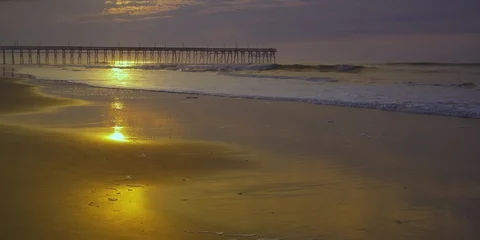 Waves rolling towards the beach and pier at a distance Stock Footage 103493894