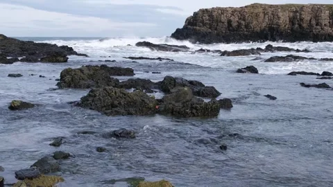 Waves rolling towards shoreline at Dunseverick Northern Ireland Vídeos de archivo 303451321