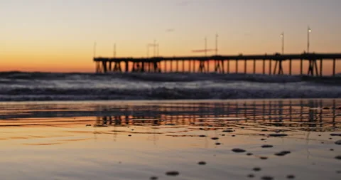 Waves rolling in on Venice Beach at sunset with pier Stock Footage 262492714