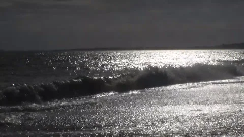 Waves run ashore. The shimmering waves in the sun. Video shot backlight. Stock Footage 92366899