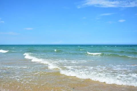 Waves run on the ocean under blue sky Stock Photos