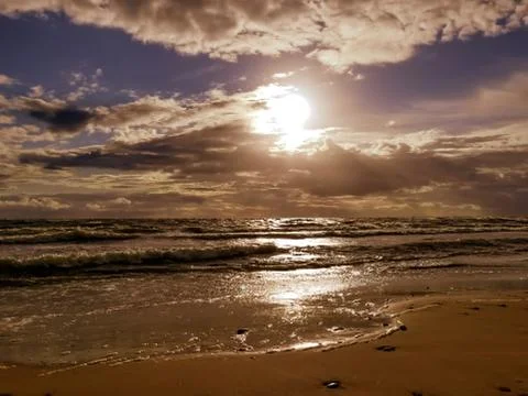 Waves run onto the sandy beach of the Baltic Sea. Stock Photos