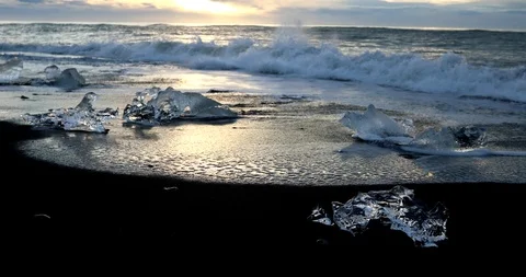 The waves run to the shore and beat against pieces of ice Vidéo 95750092