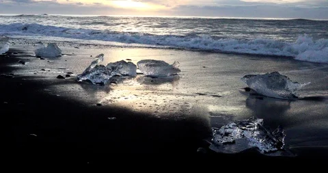 The waves run to the shore and beat against pieces of ice Stock Footage 95750096
