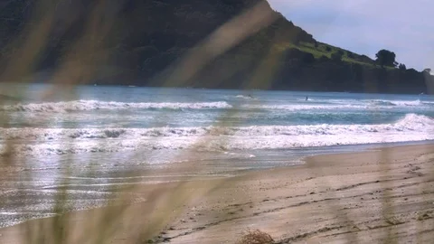 Waves rush up against a beach as jet skiers ride in the distance Stock-Footage 93722869