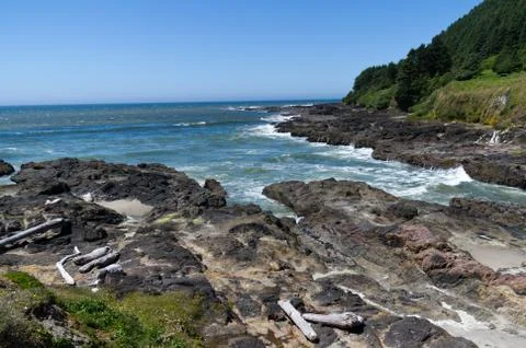 Waves rush ashore at devils punch bowl Stock Photos