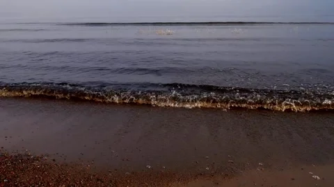 Waves rush to the sandy shore. Misty early morning. Stock Footage 124269421