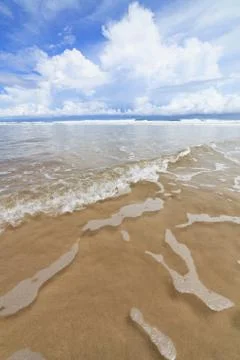 Waves sand beach and clouds sunny day Stock Photos