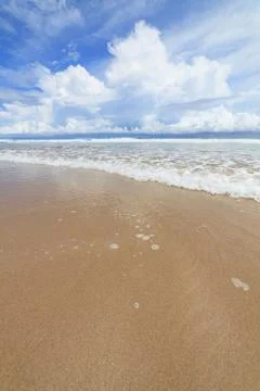 Waves sand beach and clouds sunny day Stock Photos