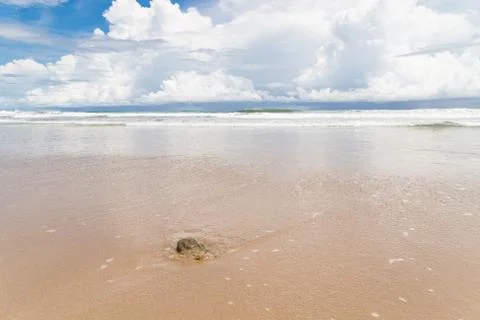 Waves sand beach and clouds sunny day Stock Photos