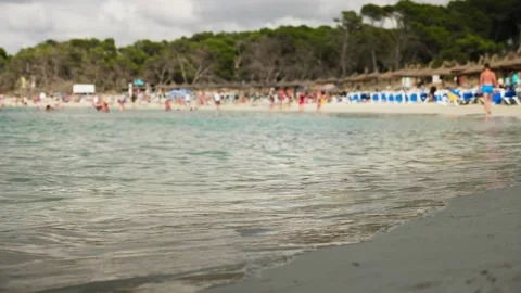 Waves at sand beach with footsteps Stock Footage 131348023