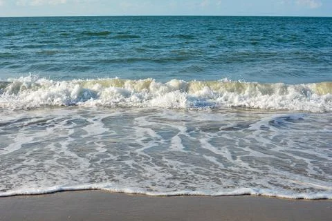 Waves on sand beach Stock Photos
