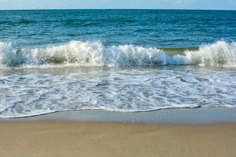 Waves on sand beach Stock Photos