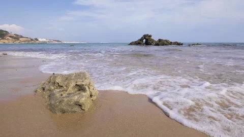 Waves on sandy beach rock slow motion Stock Footage 130870726