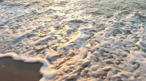 Waves on a sandy beach at sunset Stock Footage 10573847