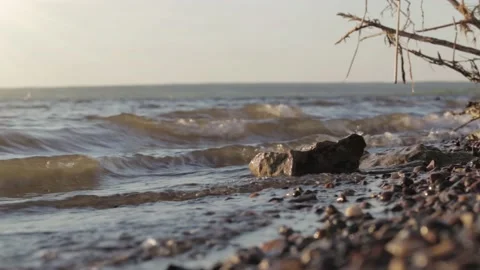 Waves of the sea are breaking on the cliffs of the coast. Sun rays  Video stock 133138059