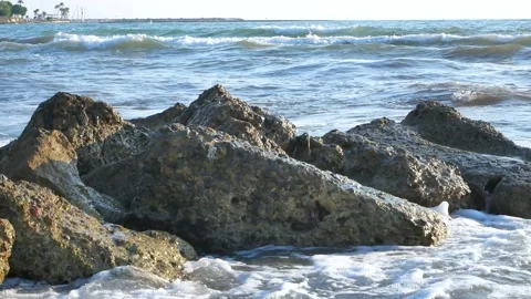 The waves of the sea hit a large rock on a deserted shore. Stock Footage 278577920
