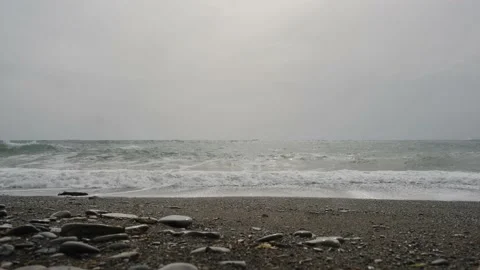 Waves on the sea pebble beach and cloudy sky Stock Footage 185194847