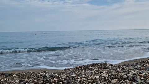 Waves in the sea. A pebble beach. The shore of the sea beach with waves in the Stock Footage 286127660